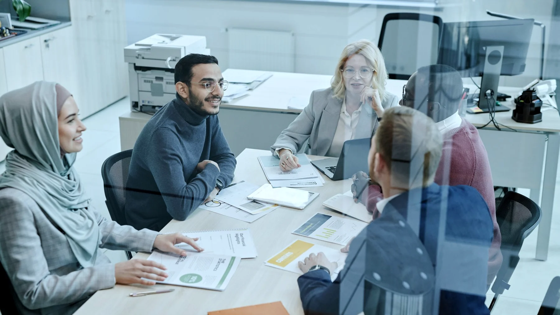 Profesionales diversos conversando en una reunión de trabajo, imagen editorial.
